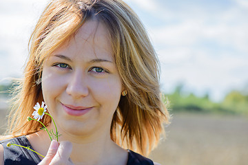 Image showing Portrait of young female with camomile