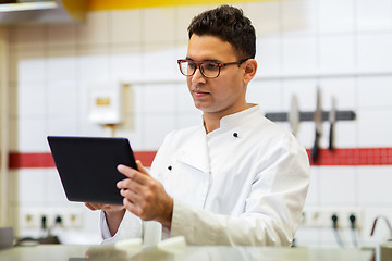 Image showing chef cook with tablet pc at restaurant kitchen