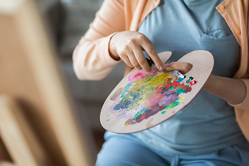 Image showing artist with palette knife painting at art studio