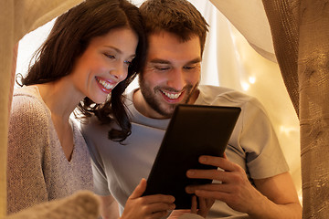 Image showing happy couple with tablet pc in kids tent at home