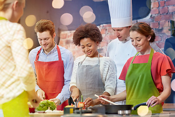 Image showing happy friends and chef cook cooking in kitchen