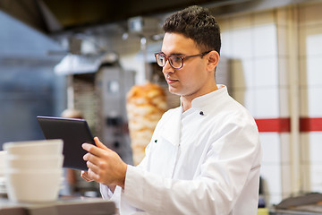 Image showing chef cook with tablet pc at restaurant kitchen