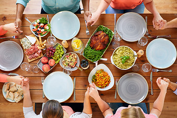 Image showing group of people at table praying before meal