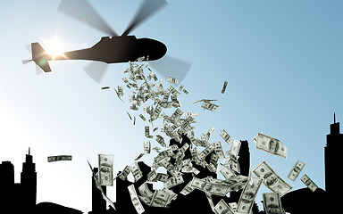 Image showing helicopter in sky dropping money over city