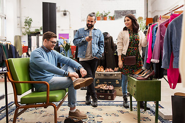 Image showing friends choosing clothes at vintage clothing store