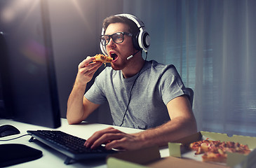 Image showing man in headset playing computer video game at home