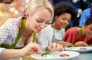 Image showing happy women cooking and decorating dishes