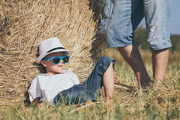 Image showing Father and son sitting in the park at the day time.