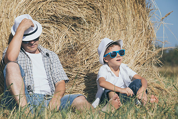 Image showing Father and son sitting in the park at the day time.