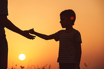 Image showing Father and son playing in the park at the sunset time.