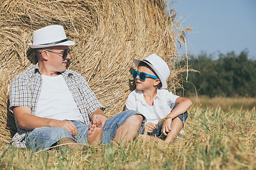 Image showing Father and son sitting in the park at the day time.