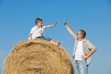 Image showing Father and son standing in the park at the day time.