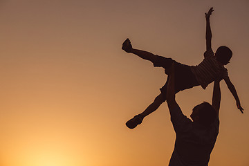 Image showing Father and son playing in the park at the sunset time.