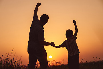 Image showing Father and son playing in the park at the sunset time.