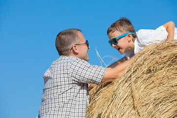 Image showing Father and son standing in the park at the day time.