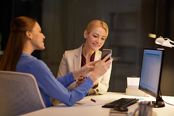 Image showing businesswomen with smartphone late at night office