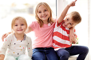 Image showing happy little kids hugging at window