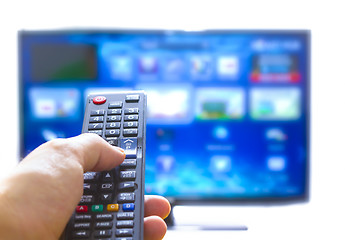 Image showing Smart tv and hand pressing remote control