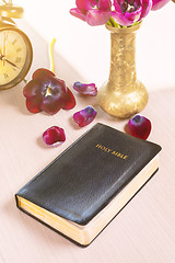 Image showing Holy Bible and old gold alarm clock on wood table