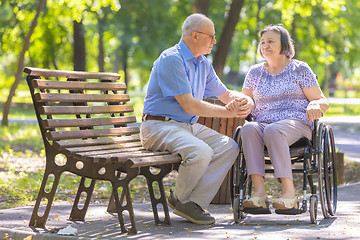 Image showing Elderly man strengthens his wife in the wheelchair 