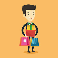 Image showing Happy man holding shopping bags and gift boxes.