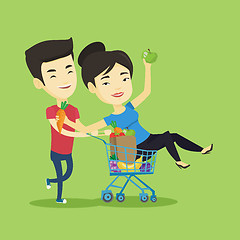 Image showing Couple of friends riding by shopping trolley.