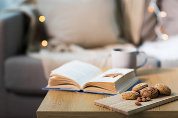 Image showing oat cookies, almonds and book on table at home