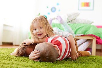 Image showing happy little kids lying on floor or carpet