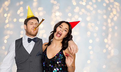 Image showing happy couple with party blowers having fun