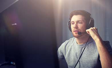 Image showing man in headset playing computer video game at home