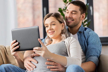 Image showing man and pregnant woman with tablet pc at home