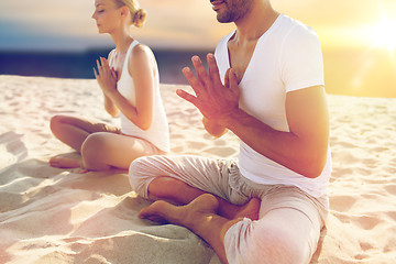 Image showing close up of couple meditating on beach