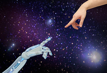 Image showing human and robot hands over space background