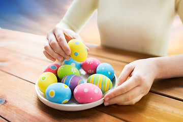 Image showing close up of woman hands with colored easter eggs