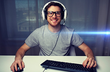 Image showing man in headset playing computer video game at home