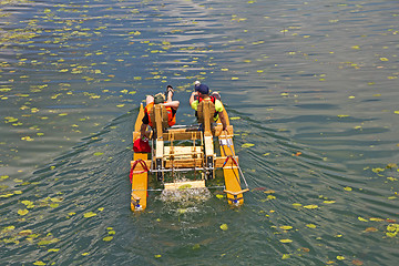 Image showing Two man ride with floating pedal bicycle boats across the lake