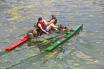 Image showing Two man ride with floating pedal bicycle boats across the lake