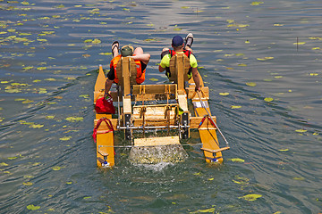 Image showing Two man ride with floating pedal bicycle boats across the lake