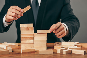 Image showing Man and wooden cubes on table. Management concept