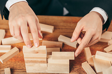 Image showing Man and wooden cubes on table. Management concept