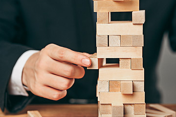 Image showing Man and wooden cubes on table. Management concept