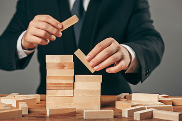 Image showing Man and wooden cubes on table. Management concept