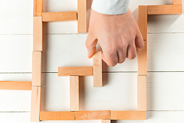 Image showing Man and wooden cubes on table. Management concept