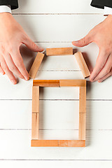 Image showing Man and wooden cubes on table. Management concept