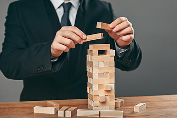 Image showing Man and wooden cubes on table. Management concept