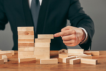 Image showing Man and wooden cubes on table. Management concept