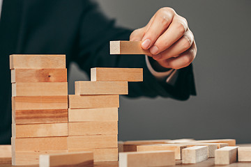 Image showing Man and wooden cubes on table. Management concept