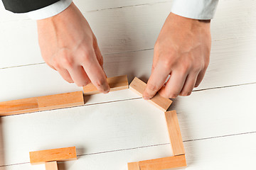 Image showing Man and wooden cubes on table. Management concept