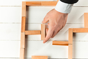 Image showing Man and wooden cubes on table. Management concept