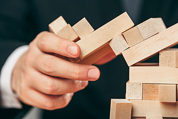 Image showing Man and wooden cubes on table. Management concept